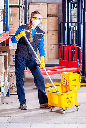 Female Warehouse Worker Mopping Floor with Safety Gear