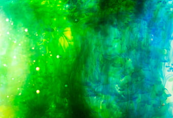 Abstract green and blue ink swirls in water background