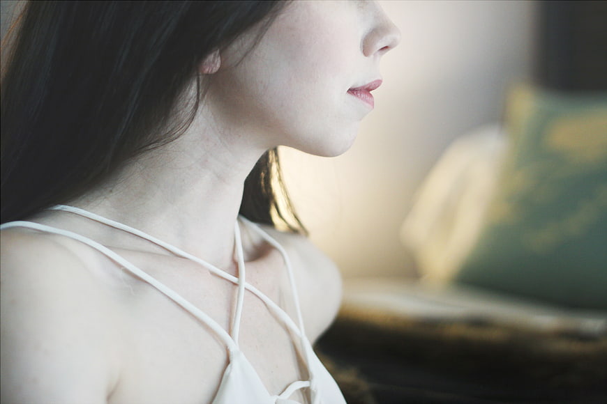 Close-up profile of a woman with dark hair in soft light