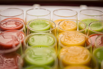 Assorted colorful fruit juices in glass cups