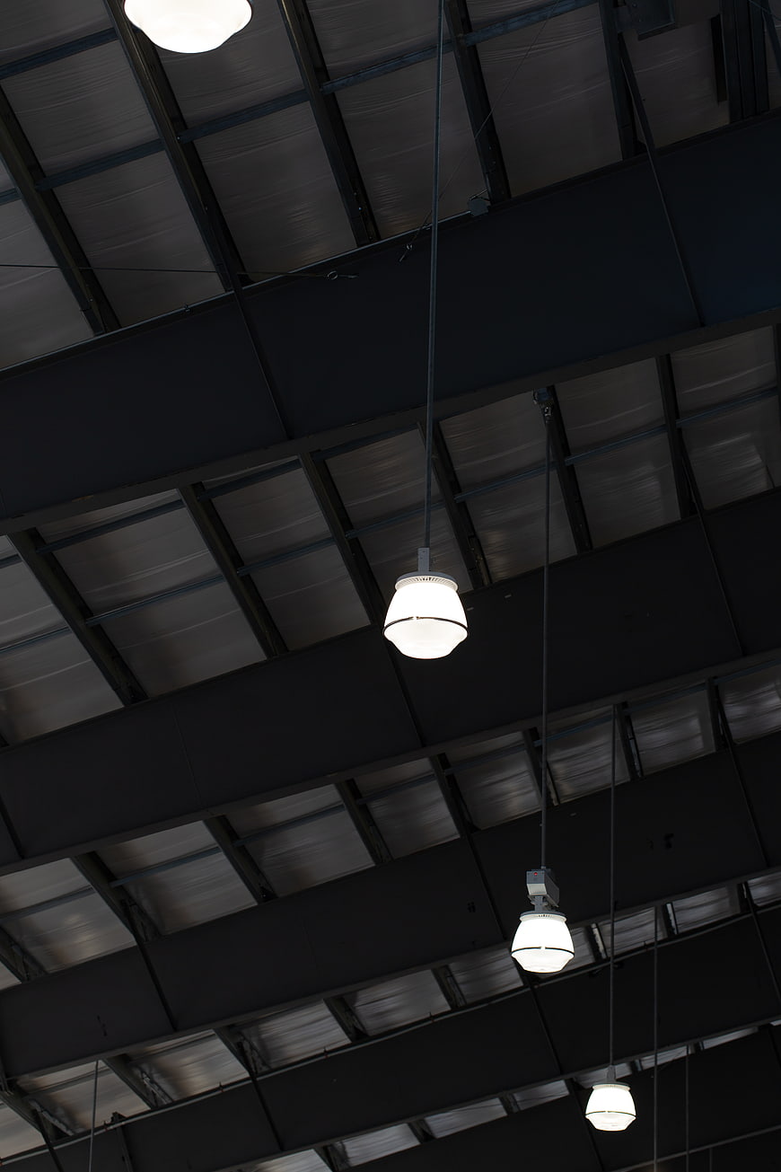 Industrial ceiling with hanging pendant lights and metal beams