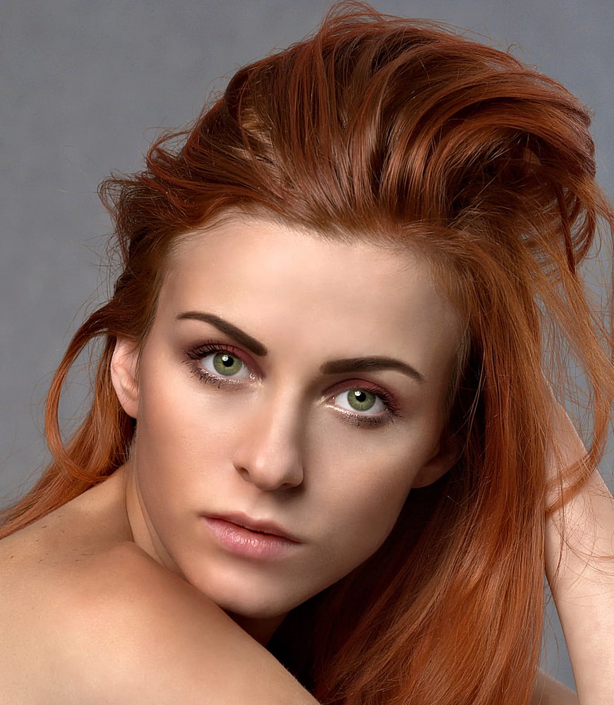 Close-up portrait of a woman with red hair and green eyes