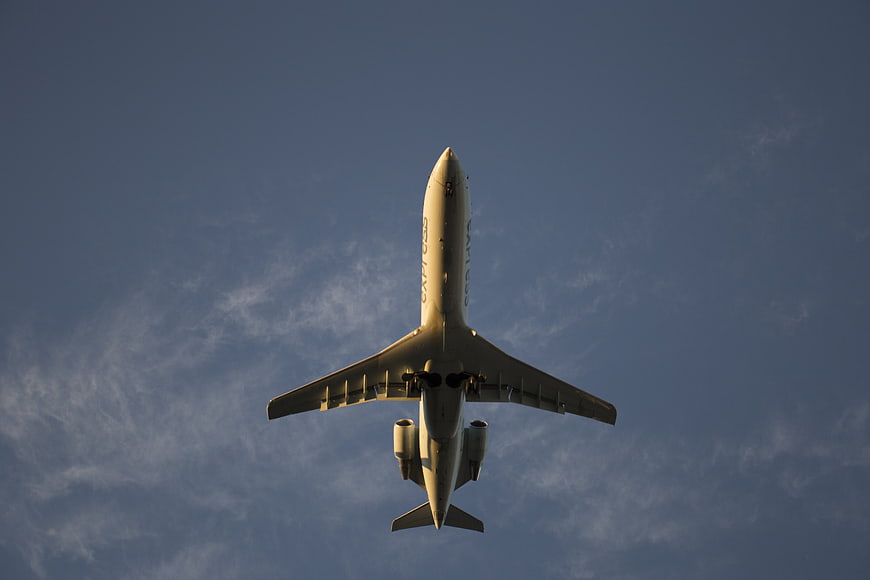 Low angle view of airplane flying in blue sky
