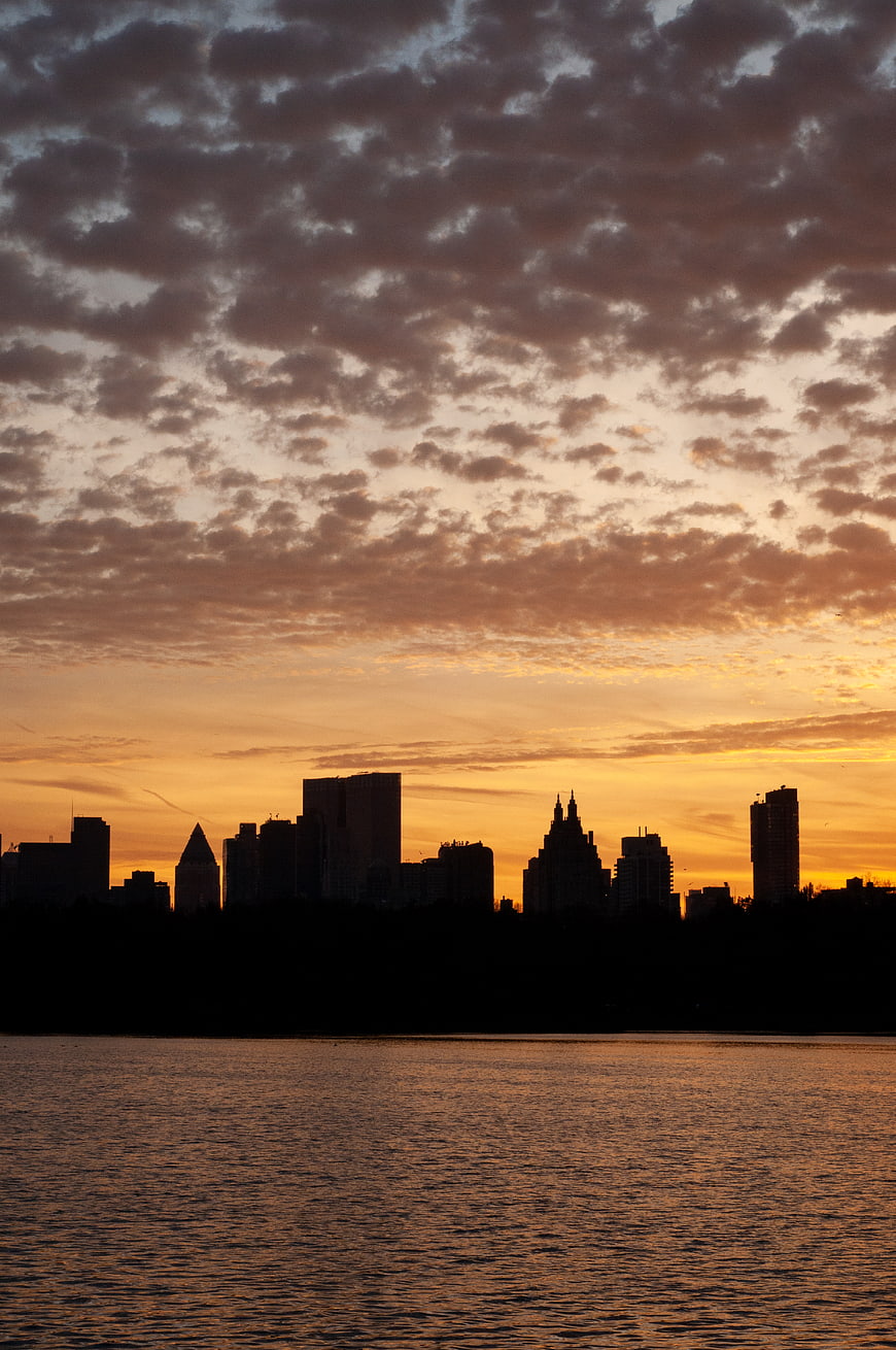 Dramatic City Skyline Silhouette at Sunset Over Water