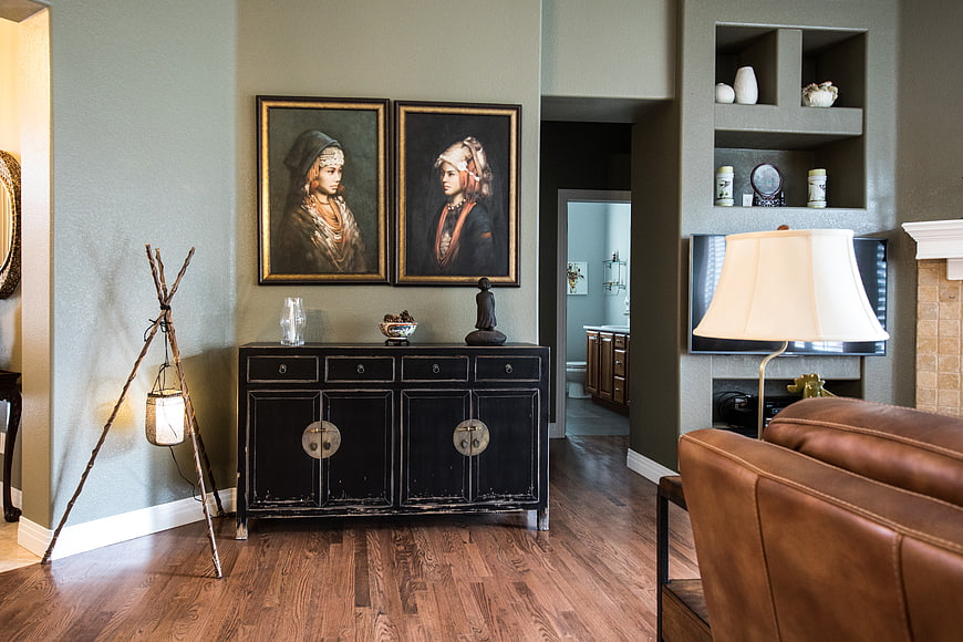 Modern living room interior with black cabinet and portraits