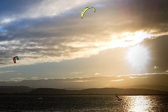 Kitesurfers Gliding on Lake at Golden Sunset