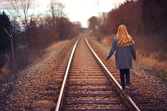Young Woman Walking on Railway Tracks in Autumn