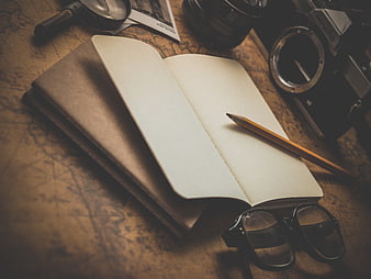 Vintage travel planning setup with notebook, camera, and map