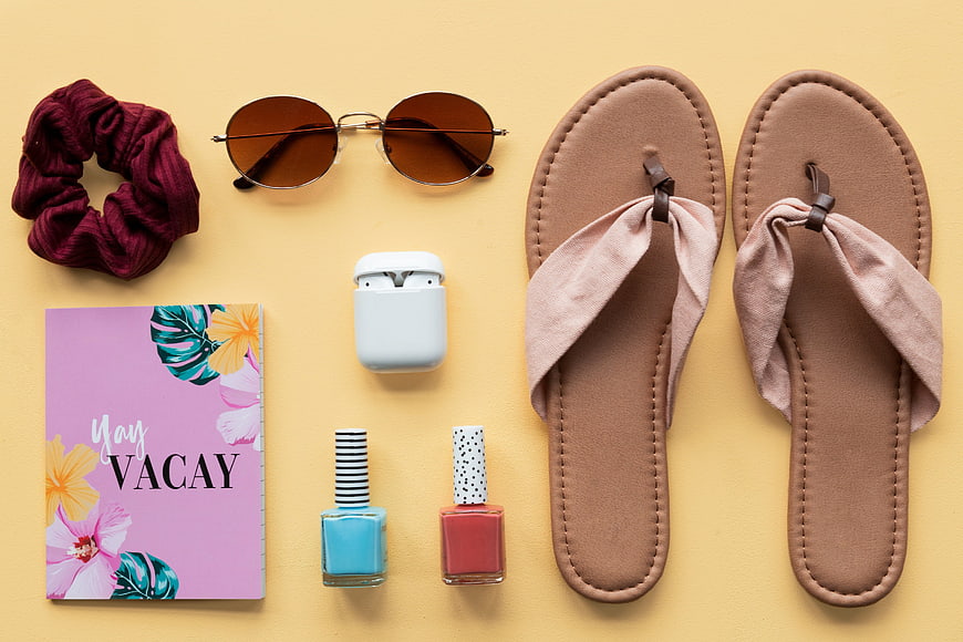 Summer vacation essentials flat lay with sandals and sunglasses