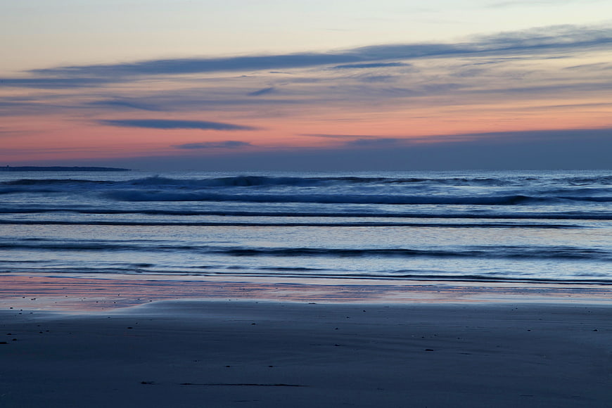 Serene Sunset Beach with Pink and Blue Sky Reflections