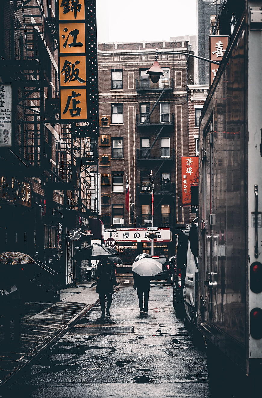 Rainy Chinatown Street with Umbrellas and Chinese Signs