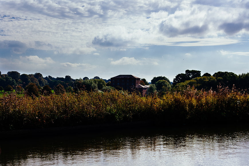 Riverside landscape with house and autumn foliage