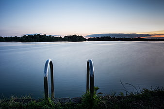 Metal Ladder at Lake Edge During Serene Sunset
