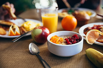 Healthy breakfast spread with oatmeal, fruit, and juice on wooden table