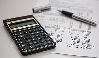 Black Calculator and Pen on Financial Investment Documents
