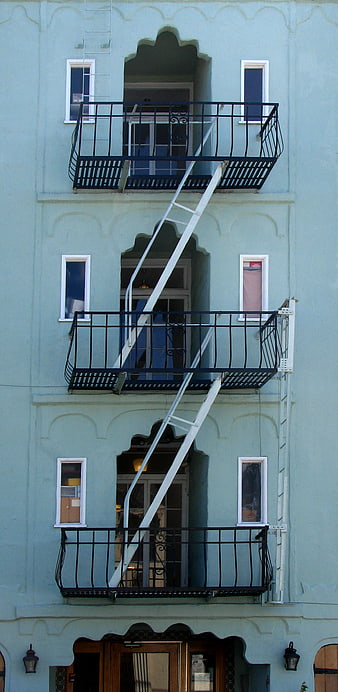 Blue building facade with white fire escape ladder