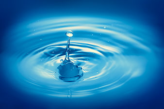 Blue water droplet splash with ripples on blue background