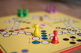 Close-up of colorful board game pieces on yellow track