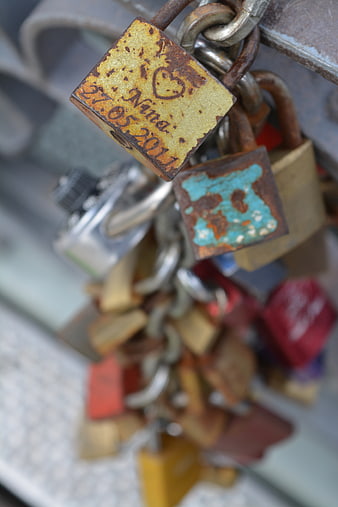 Rusty padlock with heart engraving on chain