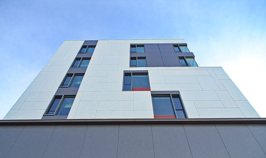 Modern Building Facade with Geometric Windows and Blue Sky