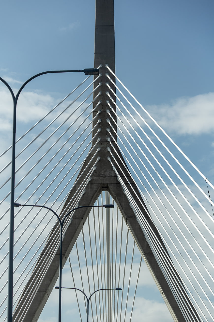 Low angle view of modern cable-stayed bridge tower against blue sky