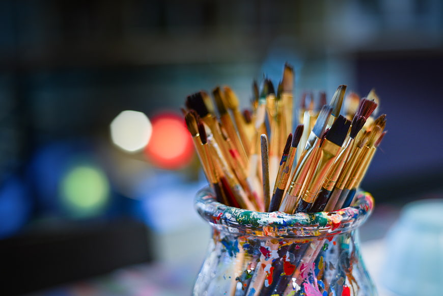 Paintbrushes in a Jar with Colorful Splatters