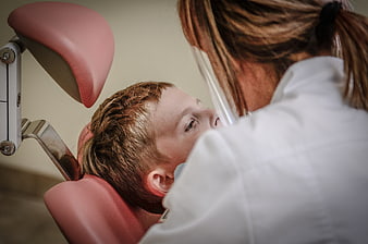 Young boy receiving dental treatment from female dentist