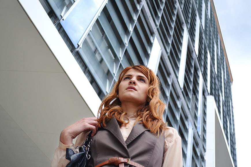 Woman in Business Attitude Looking Up at Modern Office Building