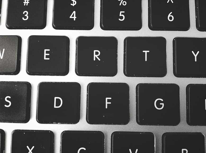 Close-up of black laptop keyboard keys on silver background