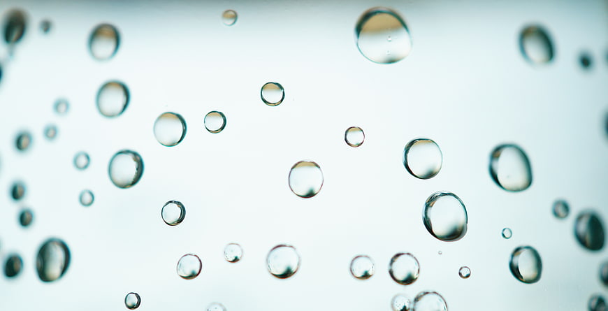 Macro shot of water bubbles rising in clear liquid