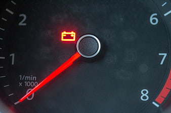 Car Dashboard Battery Warning Light and Tachometer Close-Up