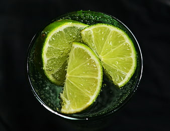 Top view of lime slices in sparkling water glass