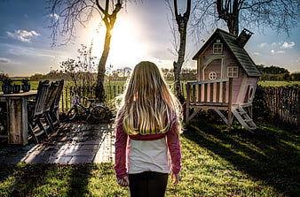 Blonde Girl Walking Toward Playhouse in Backyard