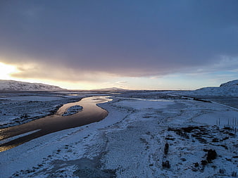 Aerial View of Winding River in Snowy Winter Landscape