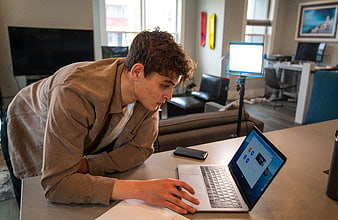 Young man working on laptop in modern office