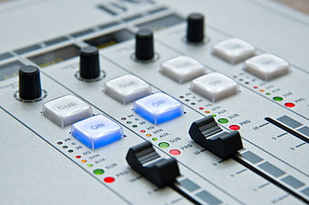 Close-up of professional audio mixing console with blue lights