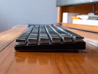 Close-up of black mechanical keyboard on wooden desk