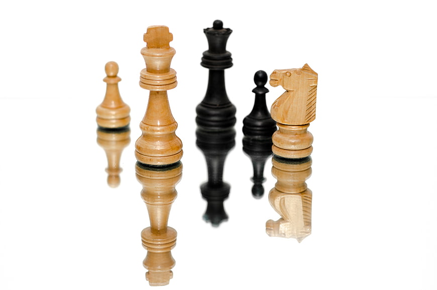 Wooden Chess Pieces with Reflection on White Background