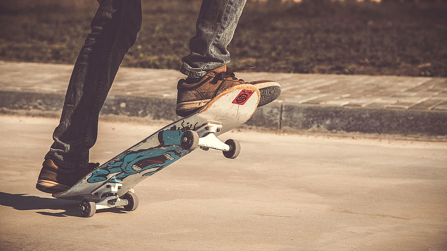 Skateboarder performing a trick on a sunny street