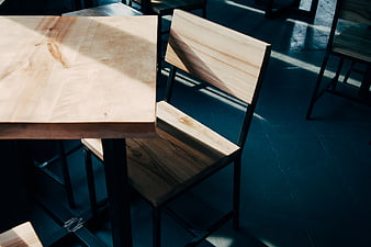 Modern wooden table and chair with sunlight shadows