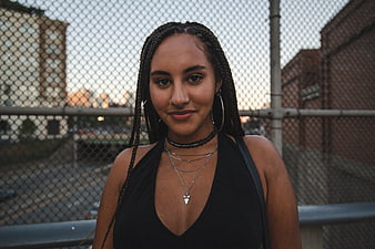 Portrait of stylish woman with braids in urban setting