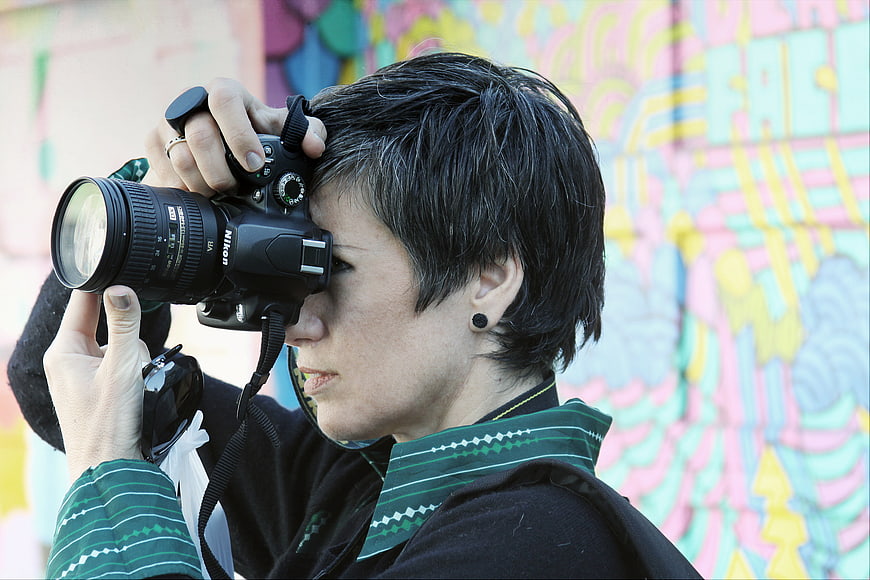 Woman Photographer with DSLR Camera Against Colorful Graffiti