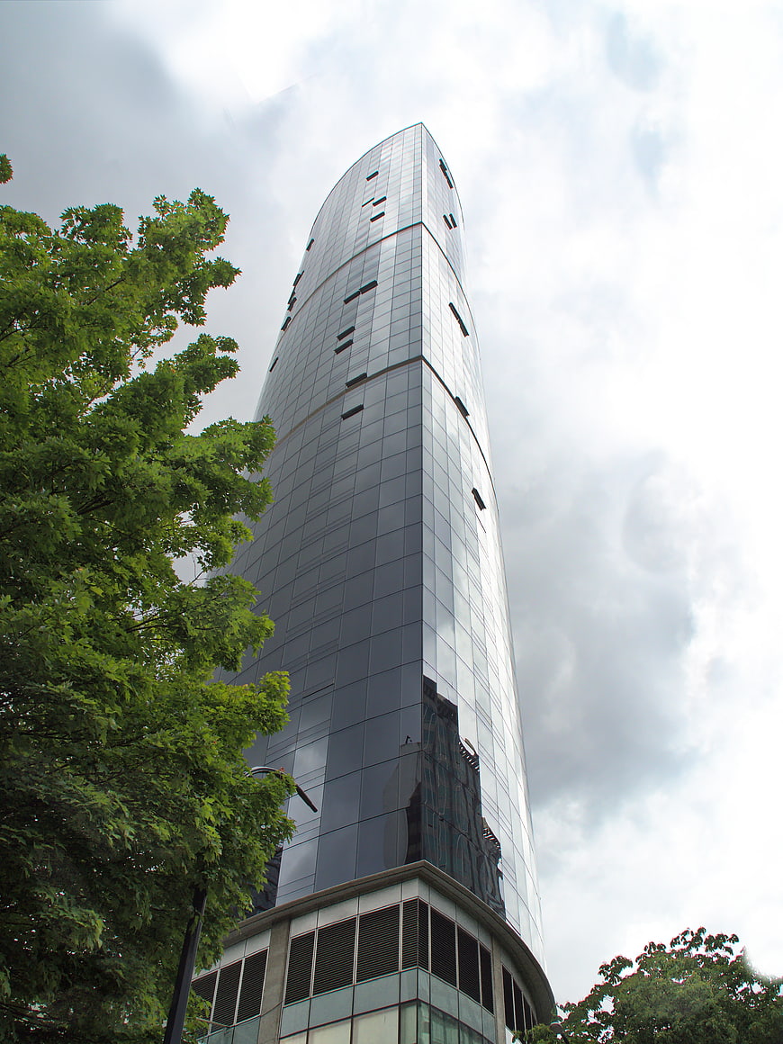 Low angle view of modern glass skyscraper with tree