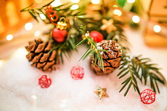 Christmas pinecones and ornaments on snow with bokeh lights