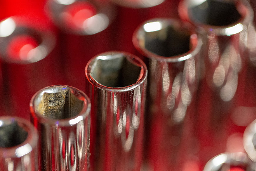 Close-up of chrome socket wrenches on red background