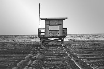 Solitary Lifeguard Tower on Sandy Beach in Black and White