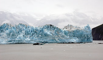 Massive Blue Glacier Face in Glacial Lake with Mountains