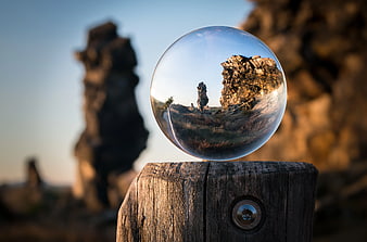 Crystal Ball Reflecting Rocky Landscape on Wooden Post