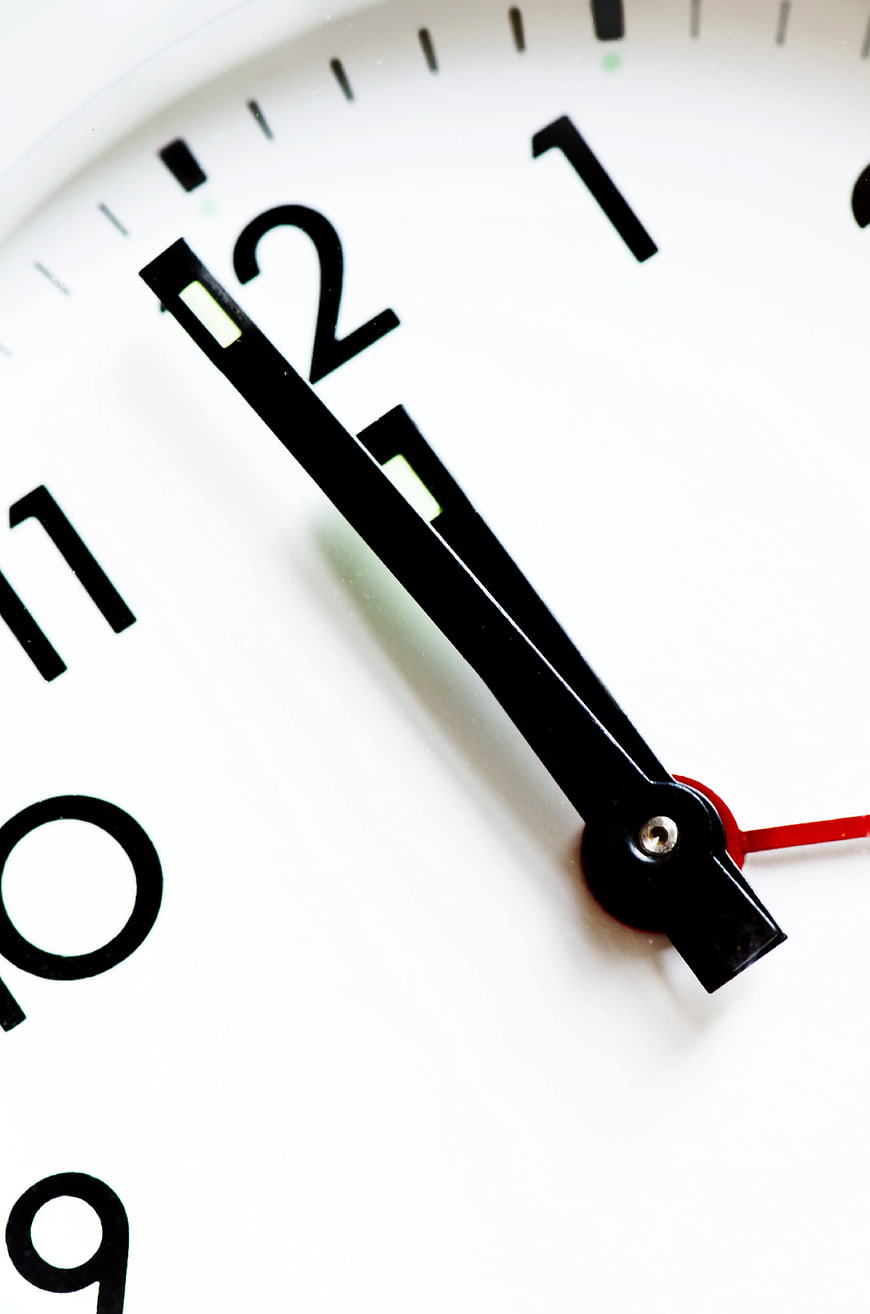 Close-up of white analog clock face with black hands