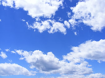 Fluffy white clouds against a bright blue sky background